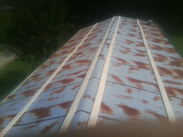 Rusted metal roof panels with new wood purlins before replacement — Storm Damage Roof Repair in Port Byron by Roofing Brothers